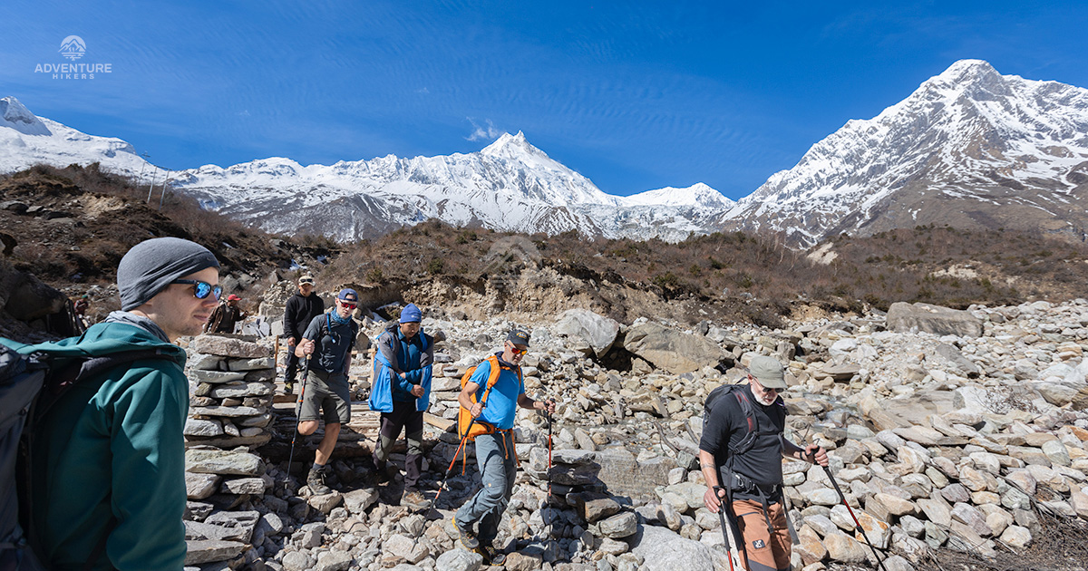 Trekkers are heading to Samdo during Manaslu Circuit Trek and Mt. Manaslu on backdrop
